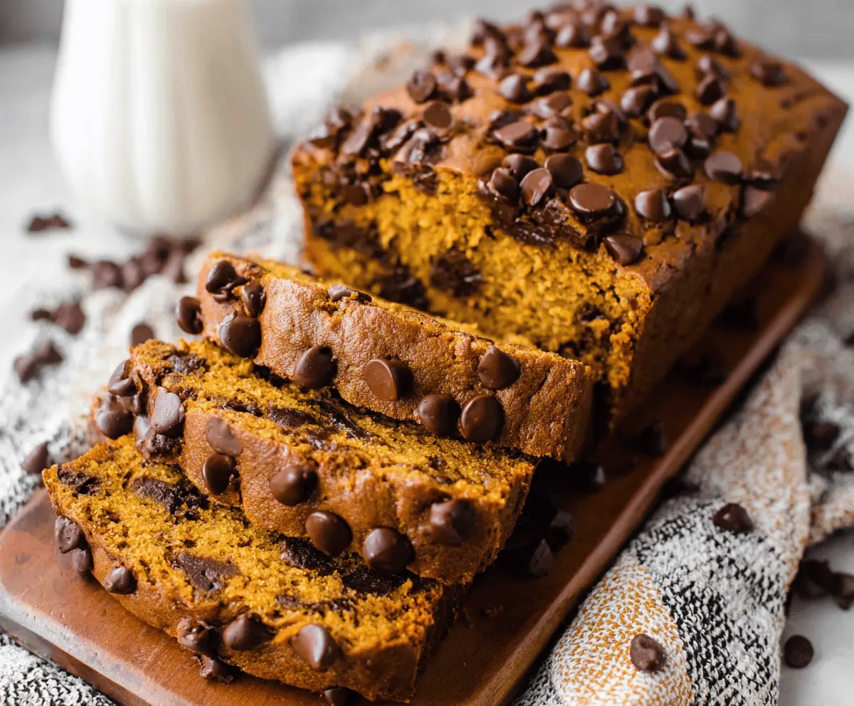 Homemade Pumpkin Chocolate Chip Bread sliced and served on a plate, featuring moist pumpkin bread filled with melty chocolate chips, perfect for fall desserts and baking.